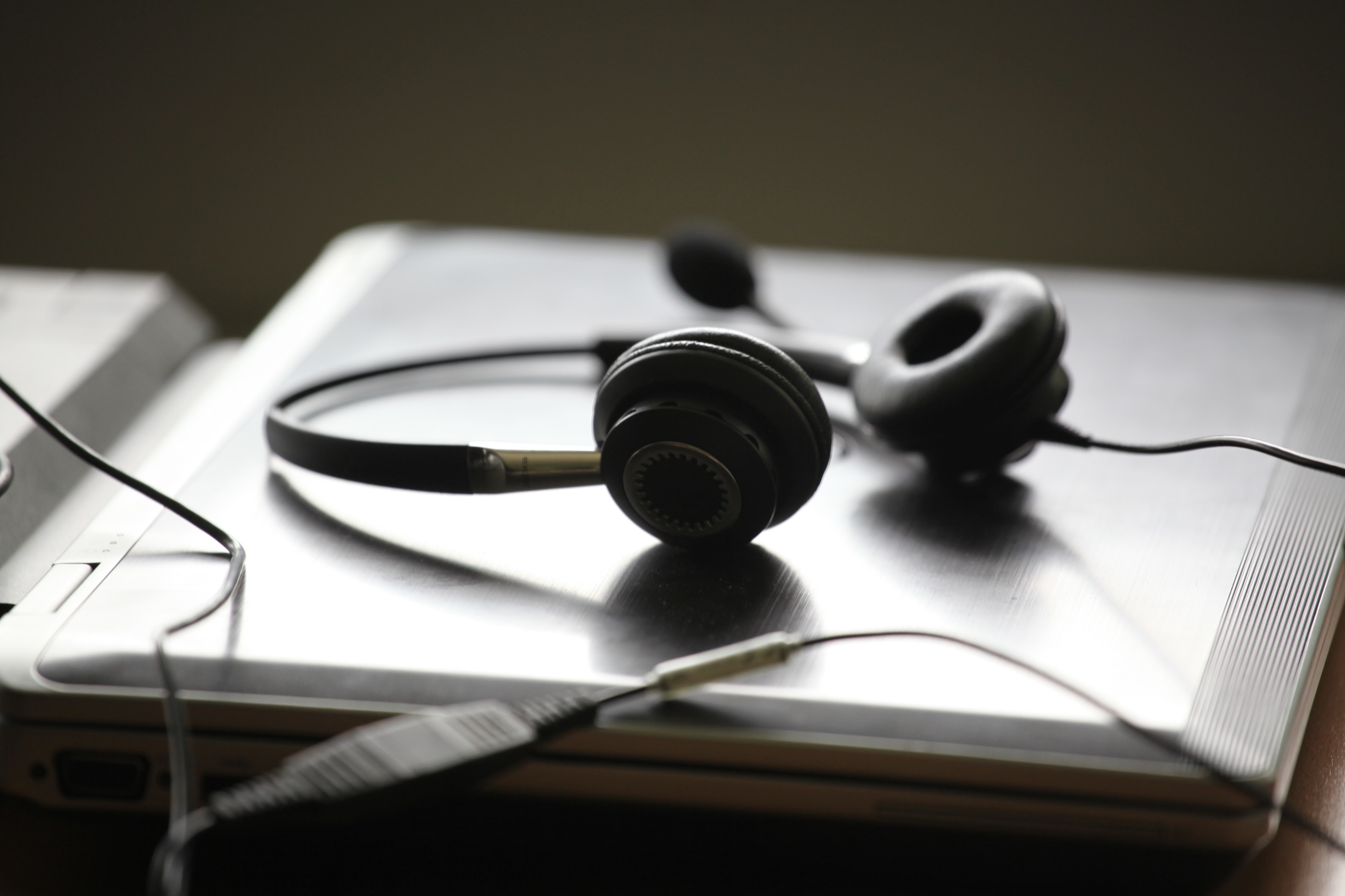 A pair of headphones lying on a laptop